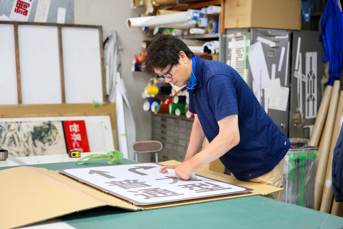 工房で道路標識を制作する有限会社マルニ工芸の職人・看板と塗装の両方に対応